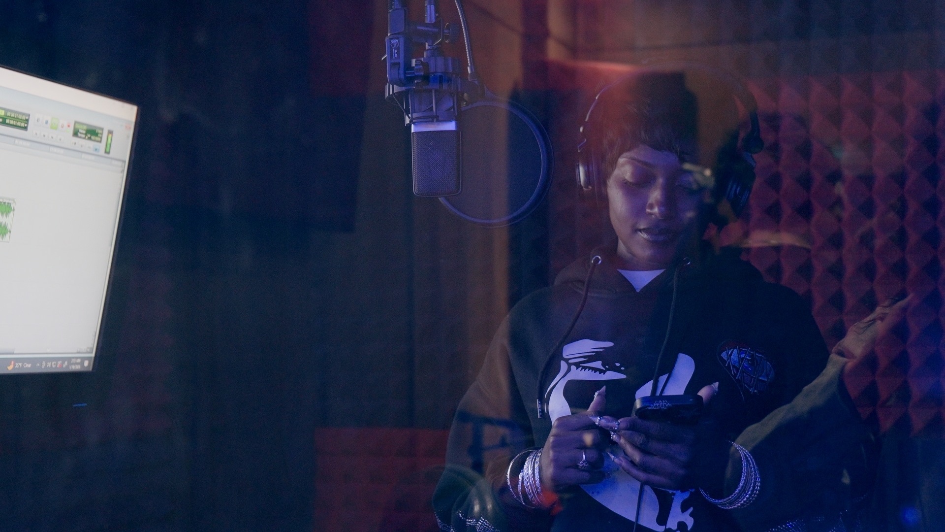 Artist in the booth under blue and red studio light